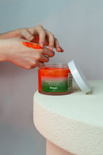 Gommage corps exfoliant doux Thé Vert Mandarine GUAPA appliqué sur la main – texture aux cristaux de sucre