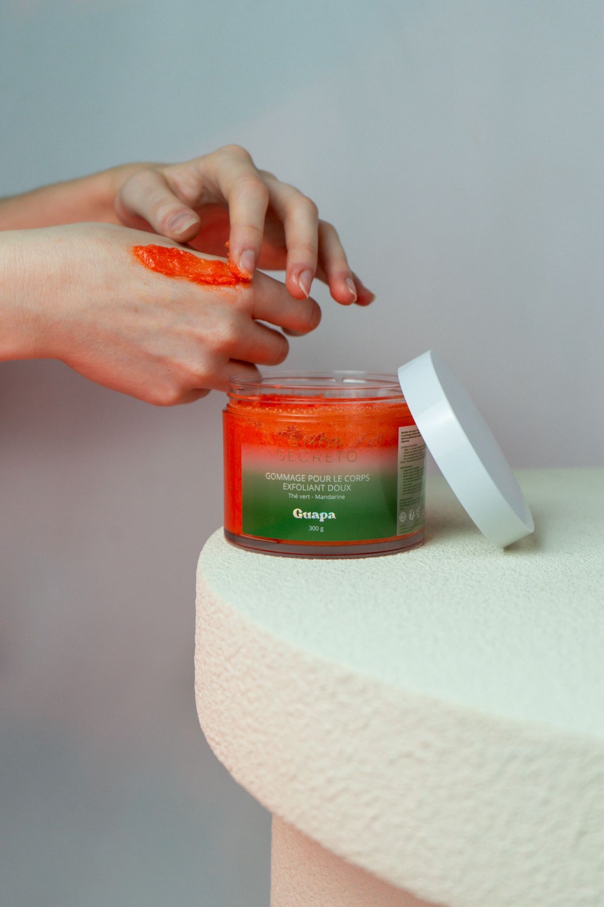 Gommage corps exfoliant doux Thé Vert Mandarine GUAPA appliqué sur la main – texture aux cristaux de sucre